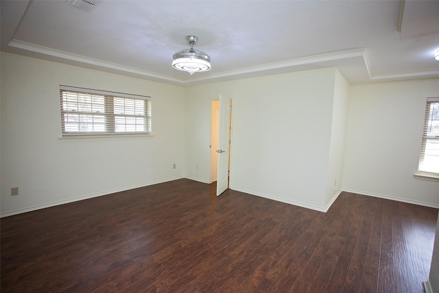 unfurnished room with visible vents, crown molding, baseboards, and wood finished floors