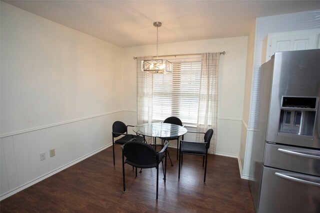 dining room featuring a chandelier, wood finished floors, and wainscoting