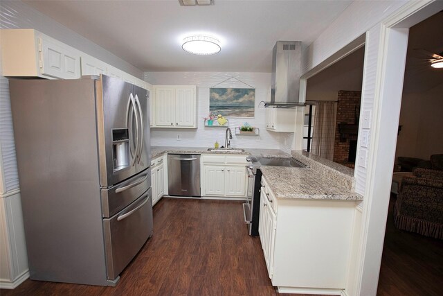 kitchen with dark wood finished floors, light stone countertops, stainless steel appliances, a sink, and exhaust hood