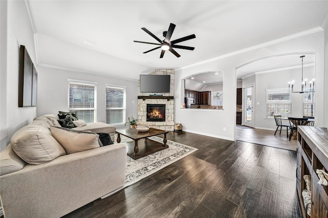 living room with ceiling fan with notable chandelier, dark wood-type flooring, a fireplace, visible vents, and baseboards