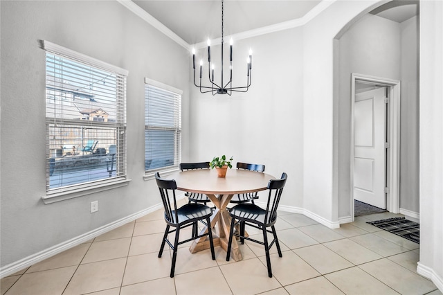 dining room featuring light tile patterned floors, baseboards, arched walkways, and ornamental molding