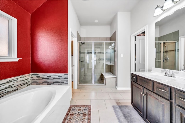 bathroom with a bath, tile patterned flooring, a shower stall, and vanity