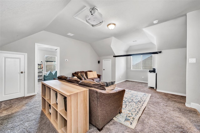 living area with lofted ceiling, baseboards, a textured ceiling, and light colored carpet