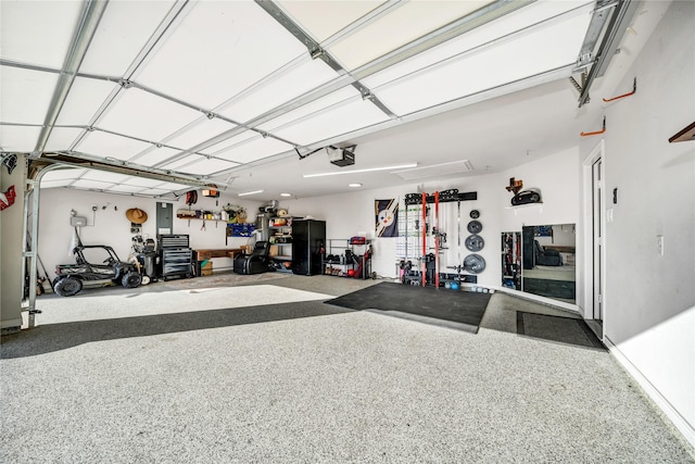 garage featuring a garage door opener, electric panel, and a workshop area