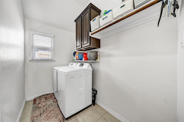 washroom with light tile patterned floors, washing machine and dryer, baseboards, and cabinet space