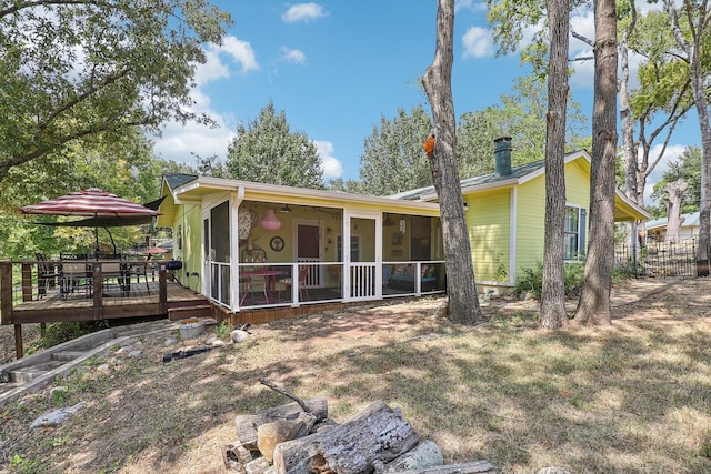 back of property featuring a sunroom and a wooden deck