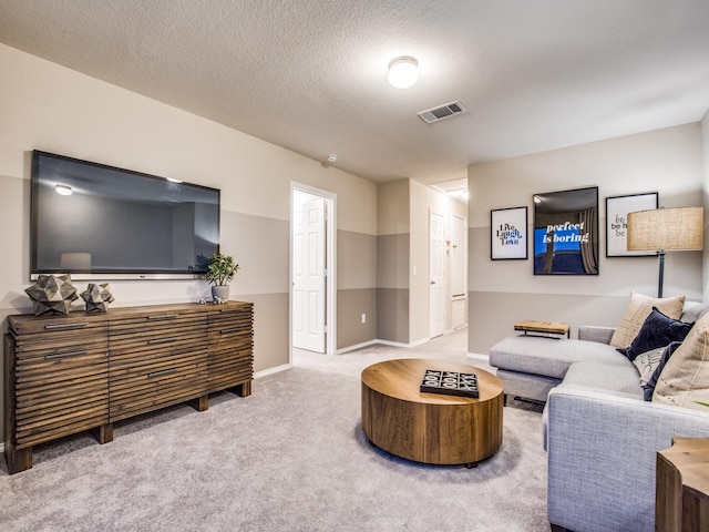 carpeted living area featuring a textured ceiling, visible vents, and baseboards