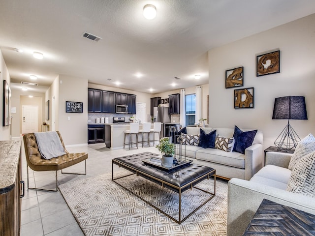 living area featuring light tile patterned floors and visible vents