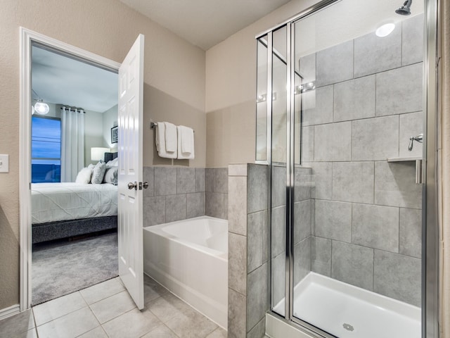 ensuite bathroom featuring a garden tub, ensuite bath, tile patterned flooring, and a shower stall