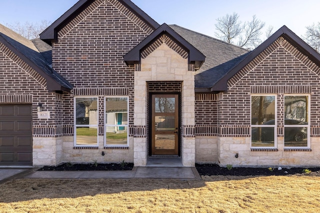 view of front of property featuring stone siding, a shingled roof, and brick siding