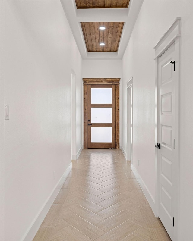 corridor with baseboards and a tray ceiling