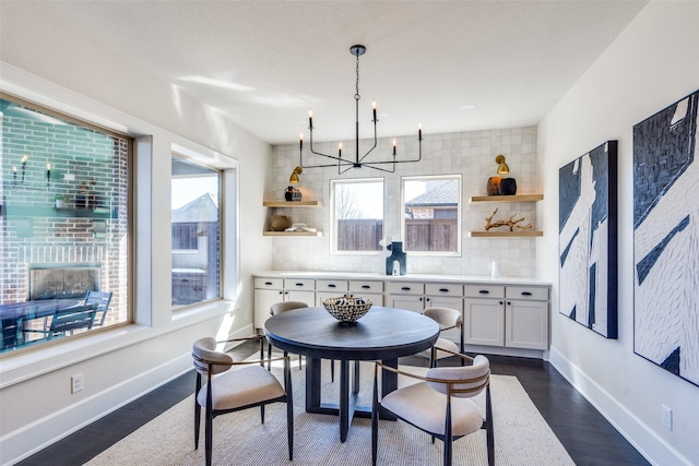 dining room featuring an inviting chandelier, baseboards, and dark wood-style flooring