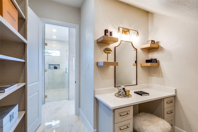 full bathroom featuring marble finish floor, a shower stall, baseboards, and vanity