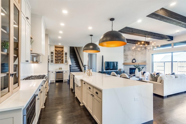 kitchen with dark wood-style flooring, wine cooler, stainless steel microwave, and a sink