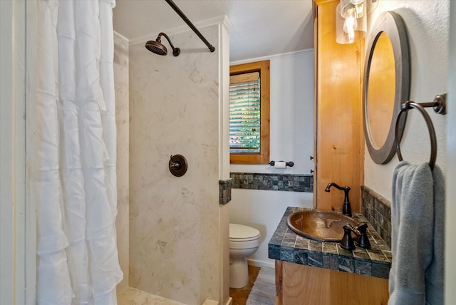 full bathroom featuring a shower with curtain, crown molding, vanity, and toilet