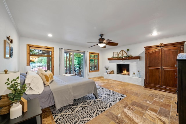 bedroom with a brick fireplace, stone tile floors, a ceiling fan, and recessed lighting