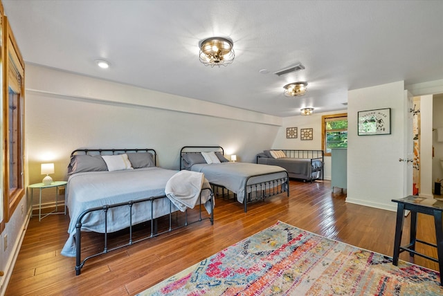 bedroom featuring visible vents, baseboards, and hardwood / wood-style flooring