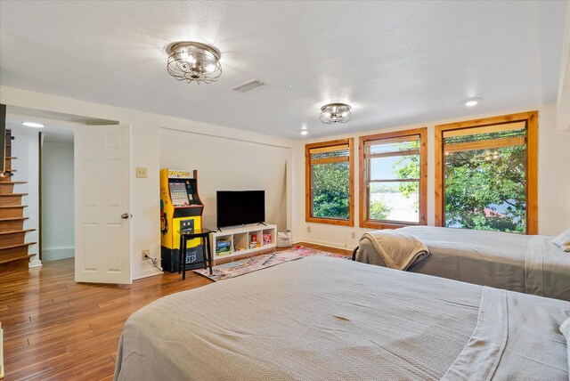 bedroom featuring wood finished floors, visible vents, and baseboards