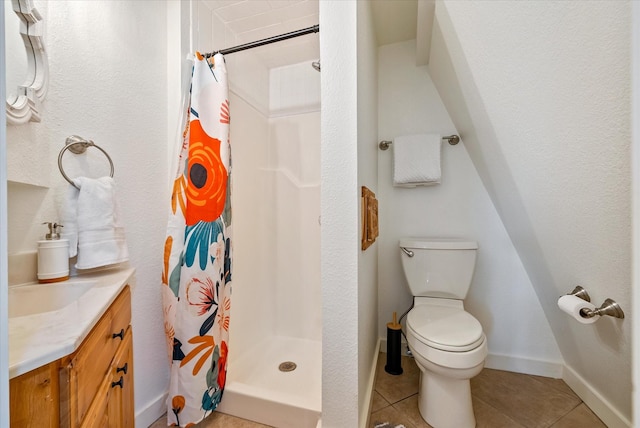 bathroom with tile patterned flooring, toilet, vanity, baseboards, and a stall shower