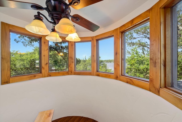 unfurnished sunroom featuring a ceiling fan