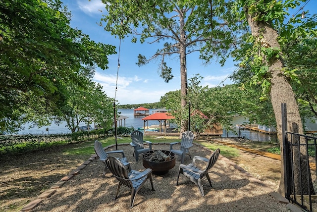 view of yard featuring an outdoor fire pit, a water view, and a gazebo