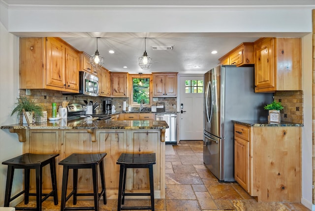 kitchen featuring stone tile floors, a peninsula, visible vents, appliances with stainless steel finishes, and dark stone counters