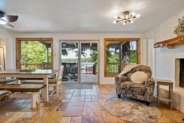 sunroom with an inviting chandelier, plenty of natural light, and a fireplace