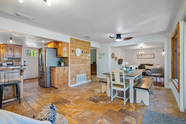 dining room featuring baseboards, visible vents, and stone tile floors