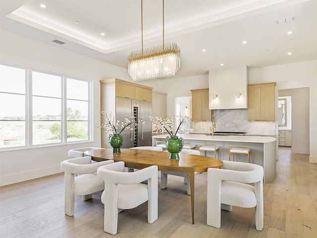 dining area with visible vents, light wood finished floors, baseboards, recessed lighting, and a raised ceiling