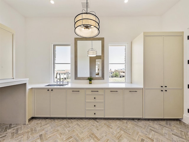 kitchen featuring a sink, visible vents, cream cabinets, and light countertops