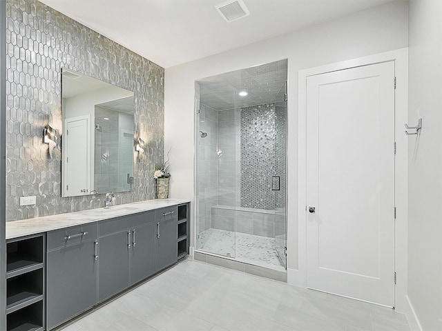 full bathroom with visible vents, a shower stall, and vanity