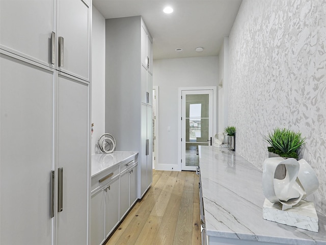 corridor featuring recessed lighting, light wood-type flooring, and baseboards