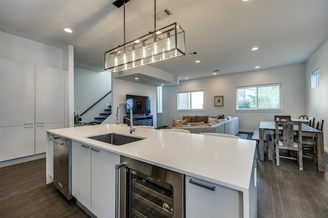 kitchen featuring dark wood-style floors, beverage cooler, visible vents, and a sink