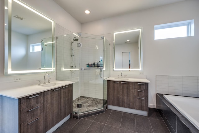 full bathroom featuring a stall shower, two vanities, and a sink