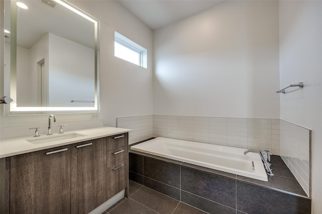 full bath featuring tile patterned flooring, visible vents, a bath, and vanity