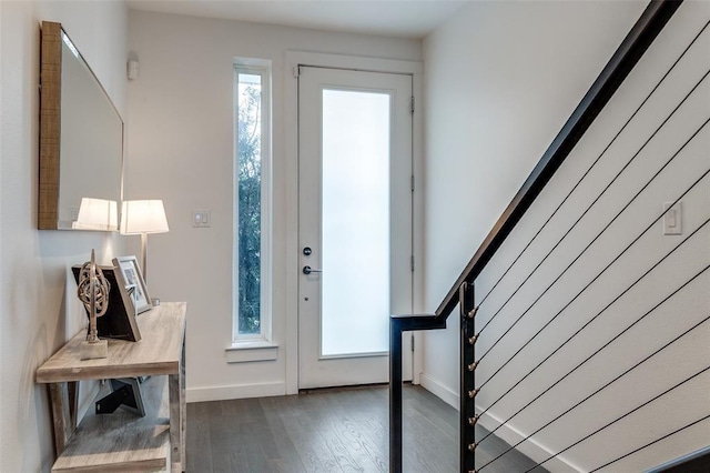 entryway featuring stairway, dark wood finished floors, and baseboards