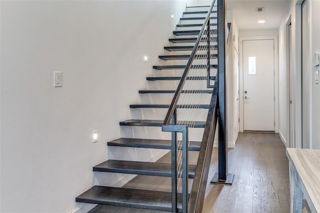 staircase featuring baseboards and hardwood / wood-style floors