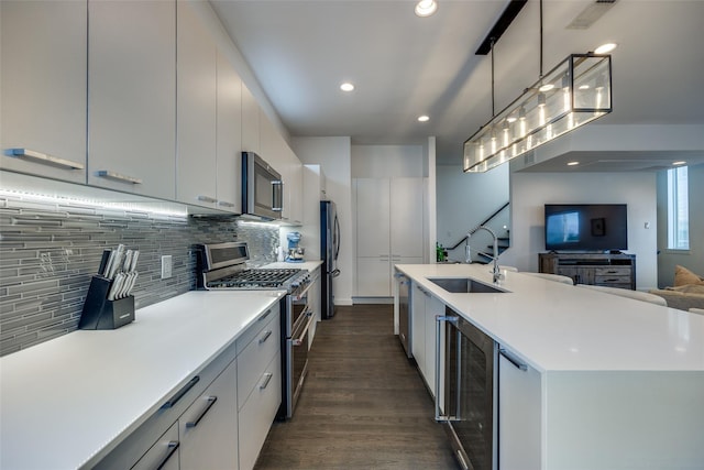 kitchen featuring beverage cooler, stainless steel appliances, dark wood-type flooring, a sink, and backsplash