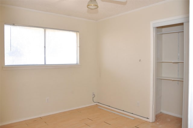 unfurnished room with light wood-style floors, ceiling fan, ornamental molding, and baseboards