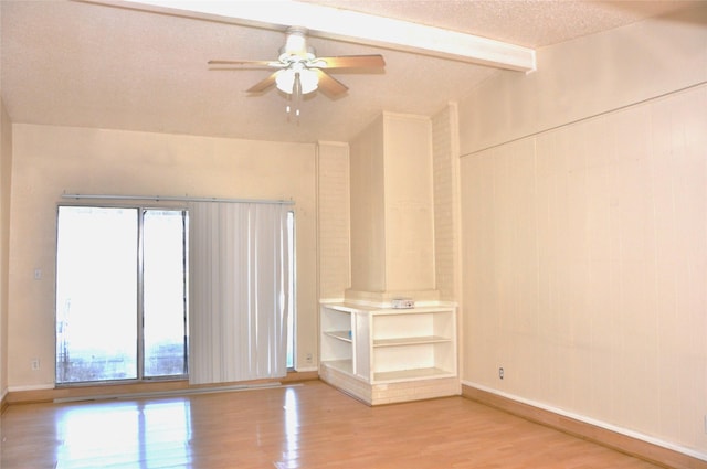 interior space with vaulted ceiling with beams, ceiling fan, a textured ceiling, light wood-type flooring, and baseboards