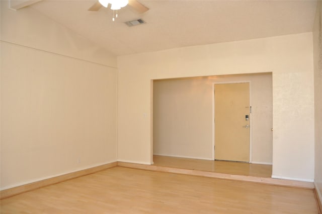 spare room with light wood-type flooring, visible vents, baseboards, and a ceiling fan