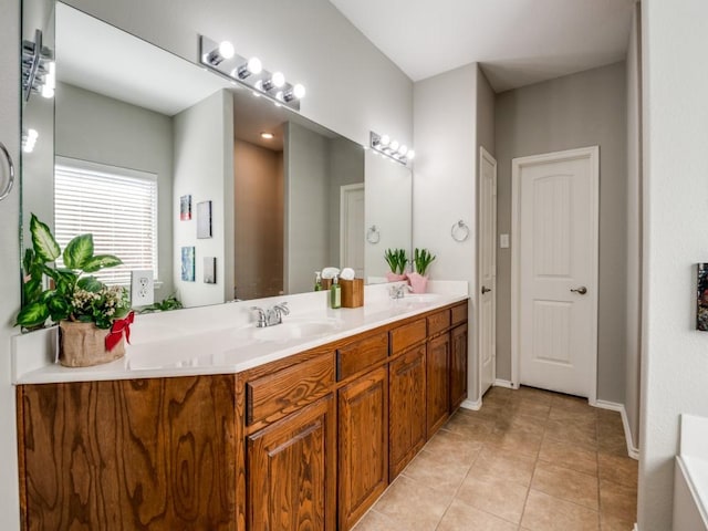 full bath with tile patterned flooring, double vanity, baseboards, and a sink