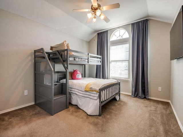 bedroom with carpet flooring, a ceiling fan, baseboards, and vaulted ceiling