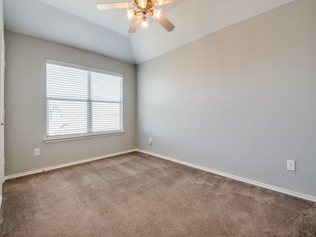 unfurnished room featuring baseboards, lofted ceiling, a ceiling fan, and carpet flooring