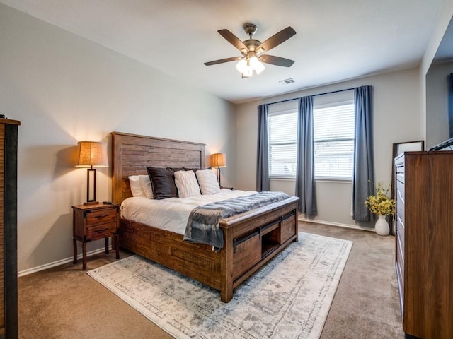 carpeted bedroom with visible vents, baseboards, and ceiling fan