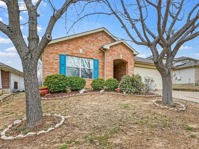 view of front of property featuring a garage, brick siding, and concrete driveway