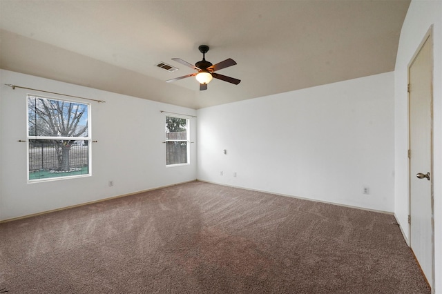 empty room with visible vents, a ceiling fan, and carpet