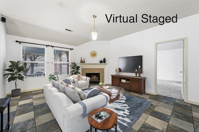 living room with visible vents, baseboards, stone tile flooring, and a tiled fireplace