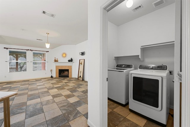 clothes washing area with laundry area, washing machine and dryer, and visible vents