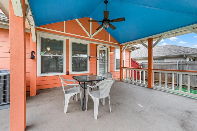 view of patio with central AC unit, outdoor dining space, a ceiling fan, and fence